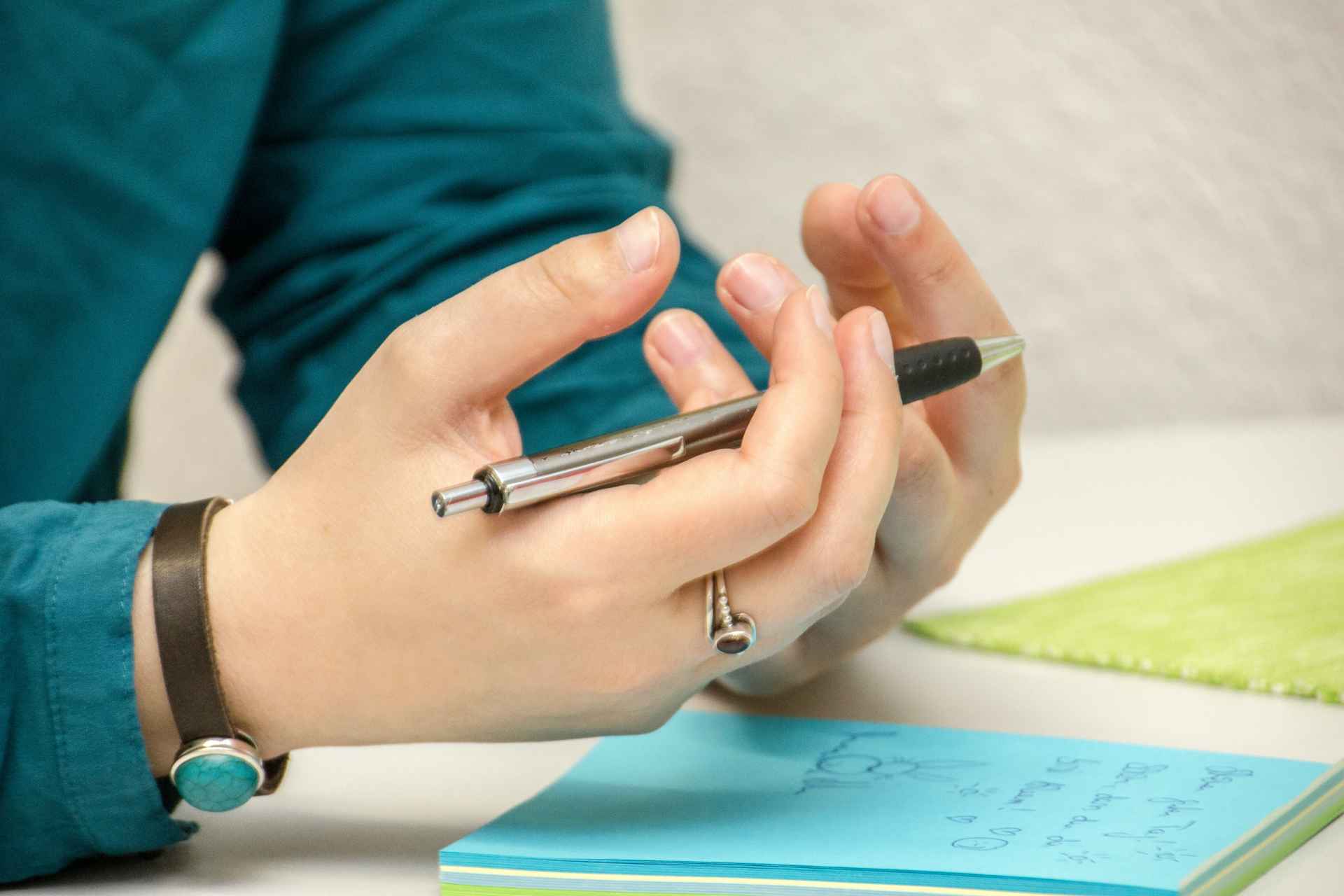 Person holding pen while working