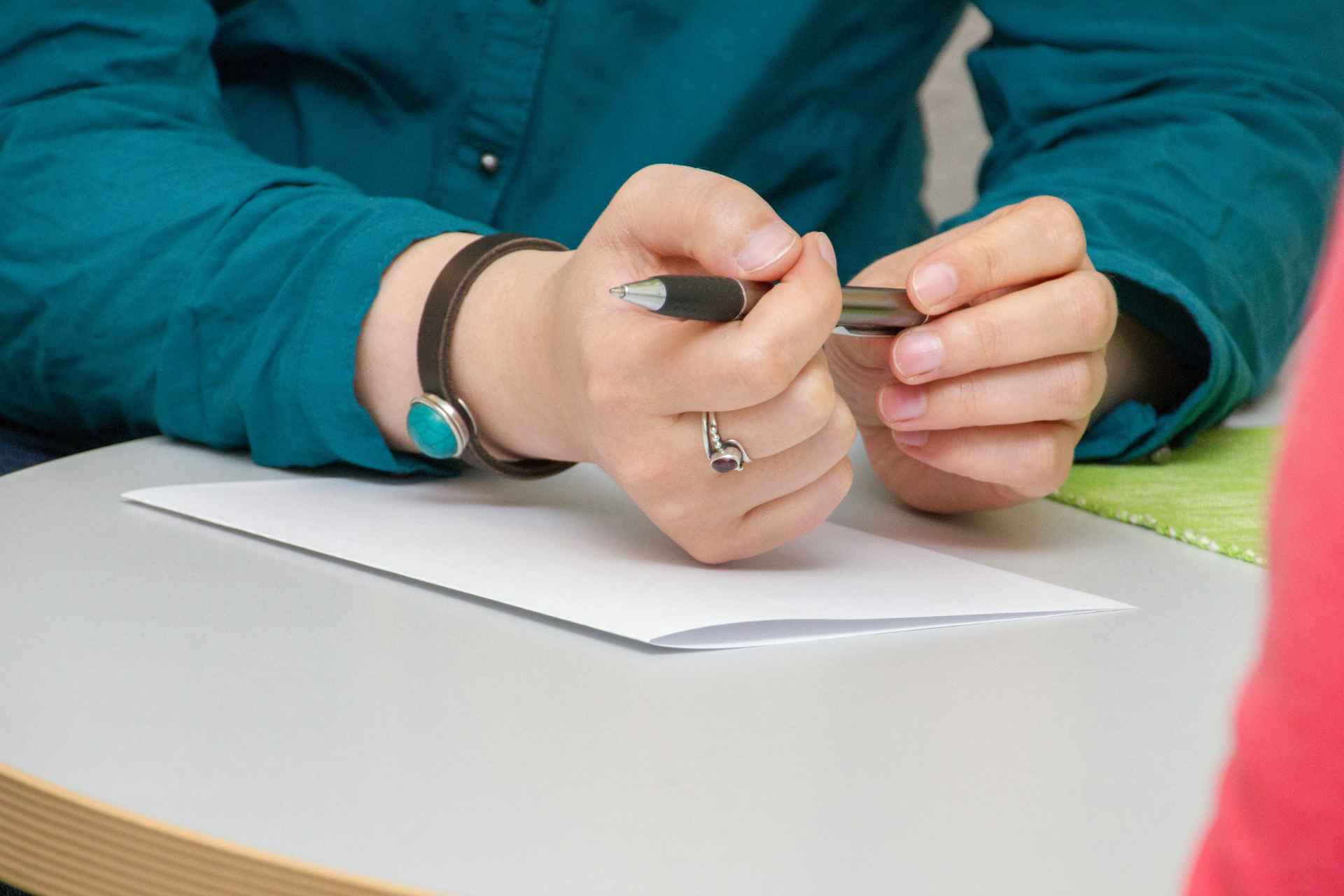 Person holding pen while working