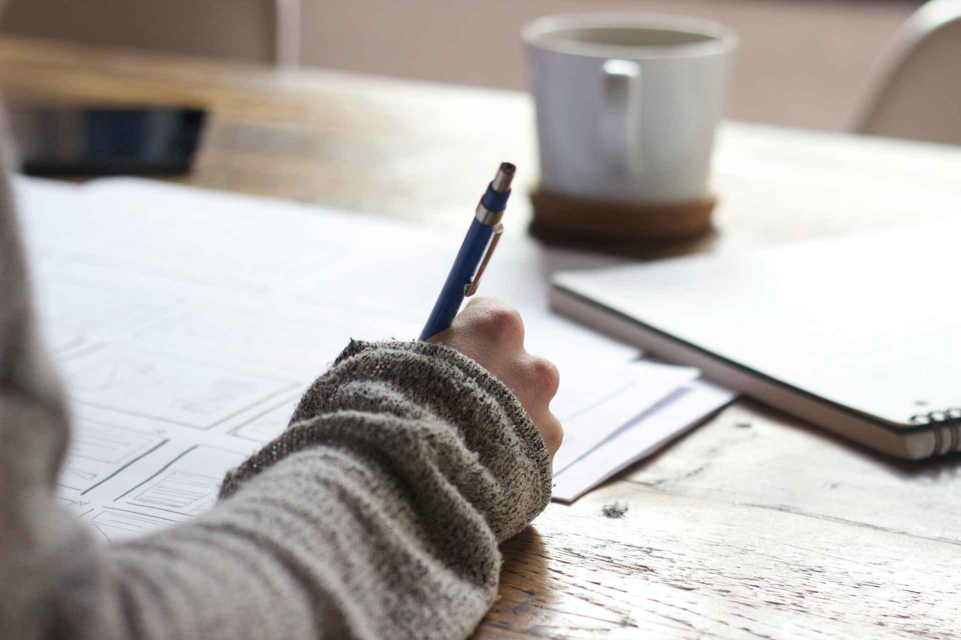 Person holding pen and writing